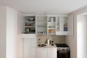 a white kitchen with white cabinets and a sink at WELCOME APARTMENTS - Luzern in Lucerne