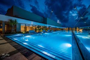 - une grande piscine dans un bâtiment la nuit dans l'établissement The Sóng Apartment Vũng Tàu - Tabo Homestay, à Vung Tau
