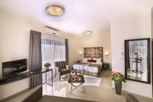 a bedroom with a bed and a living room at Shamai Suites Jerusalem in Jerusalem