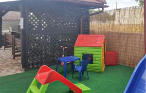 einen Spielplatz mit Spielhaus, Tisch und Stühlen in der Unterkunft Awesome Apartment In Biograd With Kitchen in Biograd na Moru