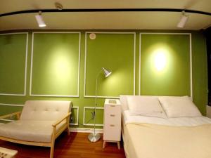 - une chambre avec des murs verts, un lit et une lampe dans l'établissement Private house near Hongdae with Elevator, à Séoul
