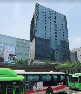 un groupe de bus garés devant un bâtiment dans l'établissement Private house near Hongdae with Elevator, à Séoul