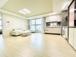 a large living room with a couch and a kitchen at Hoban Apartment, KonKuk Univ Station in Seoul