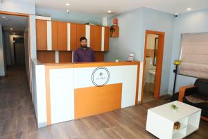 a man standing behind a counter in a room at Flora hotel in Jodhpur