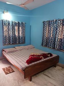 a bed in a room with blue walls and curtains at HOTEL NAKSHATRA in Digha