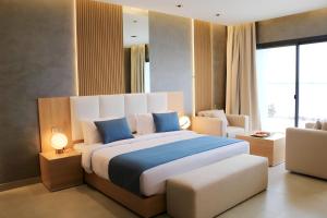 um quarto com uma cama grande e almofadas azuis em Palma Beach Resort & Spa em Umm Al Quwain