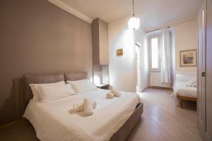 um quarto com uma grande cama branca com toalhas em DIMORA STORICA VICOLO DEL VOLTO em Iseo