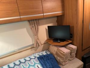 a small room with a tv and a desk with a computer at 2 bedroom caravan with gated access in Broseley