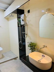 La salle de bains est pourvue d'une douche et d'un lavabo. dans l'établissement Breeze Bay Villa, à Dikwella