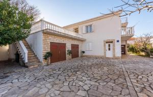 a house with a stone driveway in front of it at Amazing Apartment In Vlasici With Wi-Fi in Vlašići +17 photos