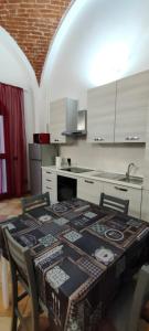 eine Küche mit einem Tisch, Stühlen und einem Waschbecken in der Unterkunft la casa di trilly in Vigevano