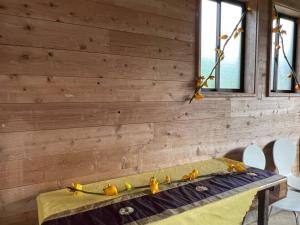 una pared de madera con una mesa con aves amarillas. en Oasis Minamiboso - Vacation STAY 04683v en Minamiboso