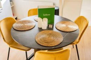 une table noire avec des chaises en or et un livre dans l'établissement Peaceful 2 Bedroom Apartment - TS307B, à Eindhoven