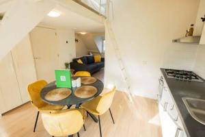 une cuisine avec une table, des chaises et un ordinateur portable. dans l'établissement Peaceful 2 Bedroom Apartment - TS307B, à Eindhoven