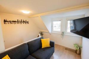 un soggiorno con divano blu e TV a schermo piatto di Peaceful 2 Bedroom Apartment (TS-307-B) a Eindhoven