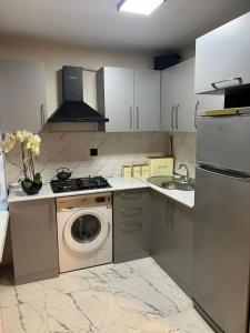 een keuken met een wasmachine en een wastafel bij Cozy nest in Baku