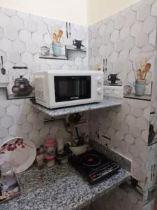 um micro-ondas sentado em cima de um balcão de cozinha em Dey Niwas em Dum Dum