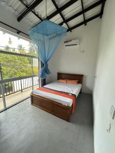- une chambre avec un lit doté d'une moustiquaire bleue dans l'établissement Lakshan home, à Ahangama
