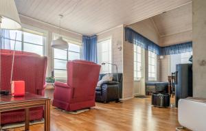 sala de estar con sillas rojas y sofá en Stunning Home In Farsund With House Sea View, en Farsund