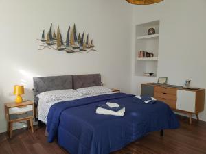 a bedroom with a bed with blue sheets and sails on the wall at Maisonvanilla in Cagliari