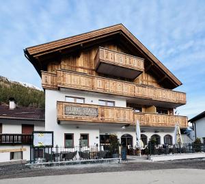 a building with a bunch of chairs in front of it at Burgstadl Aparthotel & Restaurant in Ladis