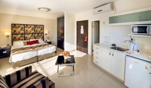 
a hotel room with a bed, table and a television at Shamai Suites Jerusalem in Jerusalem
