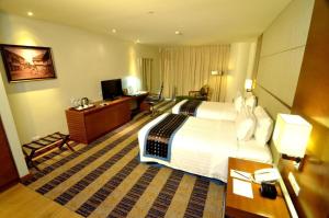 a hotel room with a large bed and a television at Lex Hotel Cebu in Cebu City