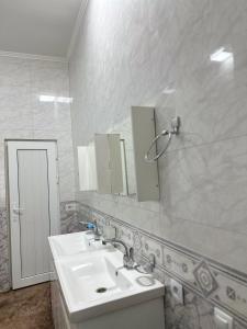 uma casa de banho com um lavatório e um espelho em Sunny Hostel em Osh