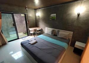 een kleine slaapkamer met een bed en een tafel bij Smile Buffalo Resort สไมล์ รีสอร์ท 