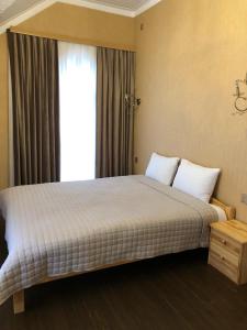 a bedroom with a large bed with a window at River View Villas in Qusar