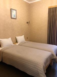 two beds in a hotel room with a window at River View Villas in Qusar