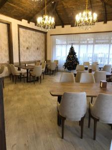 una stanza con tavoli e sedie e un albero di Natale di River View Villas a Qusar