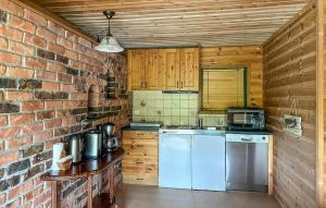 a kitchen with a brick wall and a white refrigerator at Beautiful Apartment In Sandnes With House Sea View in Bråstein