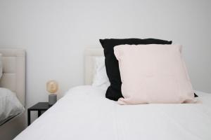 Cama blanca con almohada blanca y negra en Spacious 5 Bedroom | with Fenced Backyard, en Newport 60 fotos más