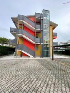 a building with a red and yellow facade at Well equipped apartment in Bibione - Beahost - in Bibione