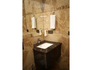 een badkamer met een grote stenen wastafel en handdoeken bij MJ Aero Suites, Joly Grant in Dehradun