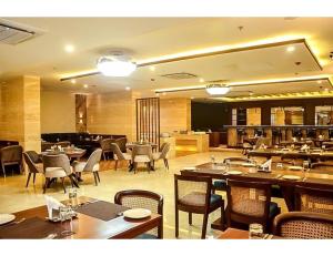 a dining room with tables and chairs and a restaurant at MJ Aero Suites, Joly Grant in Dehradun