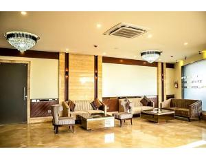 un ampio soggiorno con divani e sedie di MJ Aero Suites, Joly Grant a Dehradun