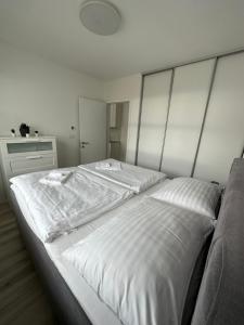 a bedroom with a large white bed with a headboard at Ein Park Apartment with free parking in Bratislava