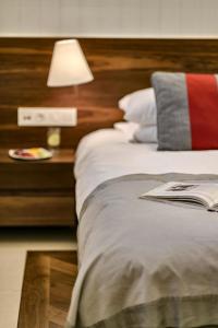 a bed with a lamp and a book on it at 12 Months Resort & Spa in Tsagarada