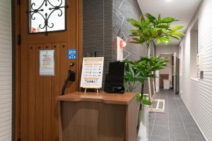 a reception desk in a hallway with a potted plant at The Peak Villa Suite Hokkaido in Higashikawa