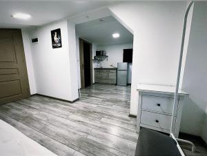 an empty living room with a kitchen and a table at Apartamenty Retro in Dąbrowa Górnicza