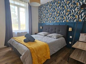 una camera da letto con un letto con una coperta gialla e una parete blu di Kings View a Roche-la-Molière