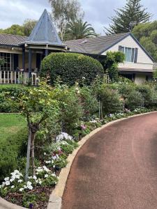 a house with a garden of flowers in the driveway at Rosewood Guesthouse in Margaret River Town