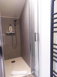 a shower with a glass door in a bathroom at Suite Mansardée indépendante, 25min Lyon-Villefranche in Chazay-dʼAzergues