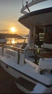 un barco está atracado en un muelle con la puesta de sol en Hotel Boat Cardeli, en Gijón