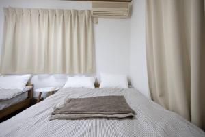 sypialnia z łóżkiem z kocem w obiekcie 所沢レイクサイドハウス w mieście Higashiyamato