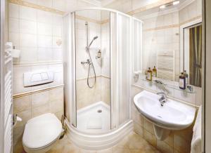 a bathroom with a shower and a toilet and a sink at Grand hotel Starý Smokovec in Vysoke Tatry - Stary Smokovec