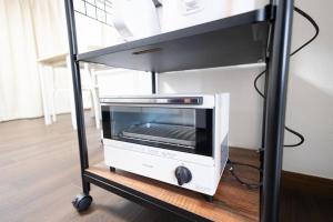 a microwave oven sitting on top of a cart at 所沢レイクサイドハウス in Higashiyamato