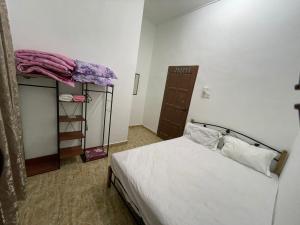 een kleine slaapkamer met een bed en een plank bij Teratak Zaa D’Homestay in Kota Bharu